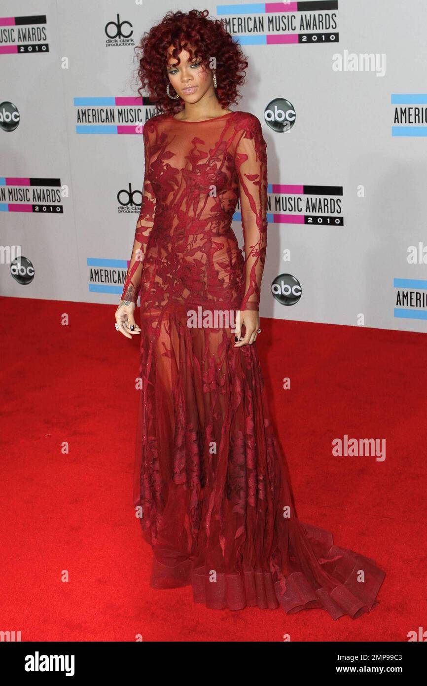 Rihanna está roja con un vestido sin espalda de encaje transparente y el  pelo rojo ardiente en los Premios de la Música Americana 2010 en el Nokia  Theatre L.A. En directo. Los