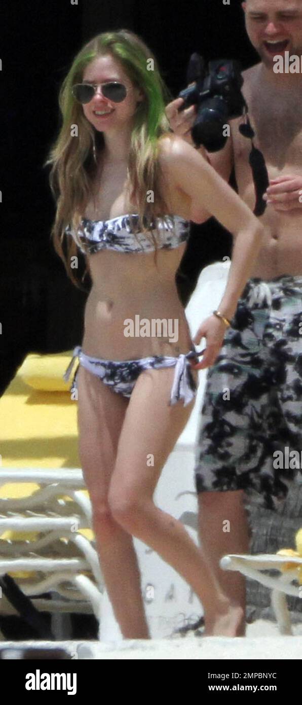 EXCLUSIVO! Avril Lavigne muestra su figura en forma en un bikini blanco y  negro durante una escapada a la playa con su banda y su hermano, Matt  Lavigne, en el Atlantis Paradise