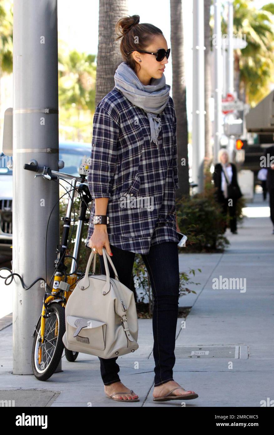 La actriz Jessica Alba se vuelve casual con una camisa de cuadros, bufanda  gris, pantalones negros y chanclas mientras paga por el estacionamiento a  un metro mientras hace recados en Beverly Hills,