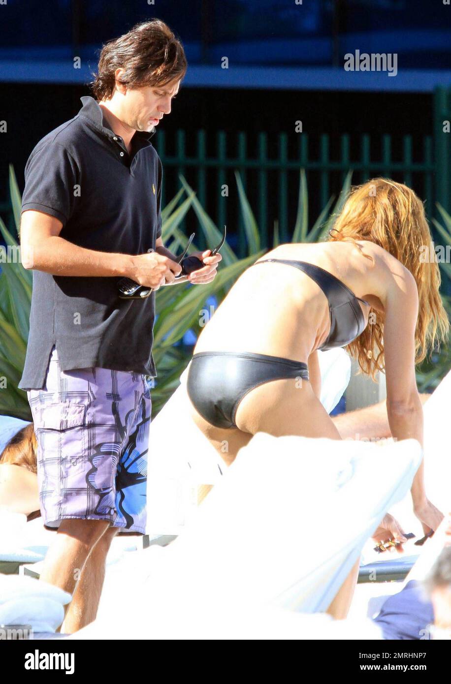 Kelly Bensimon descansa junto a la piscina en un bikini de cuero negro en  el Fontainebleau Miami Beach con el publicista Jonathan Cheban. Los dos  toman el sol mientras charlan antes de