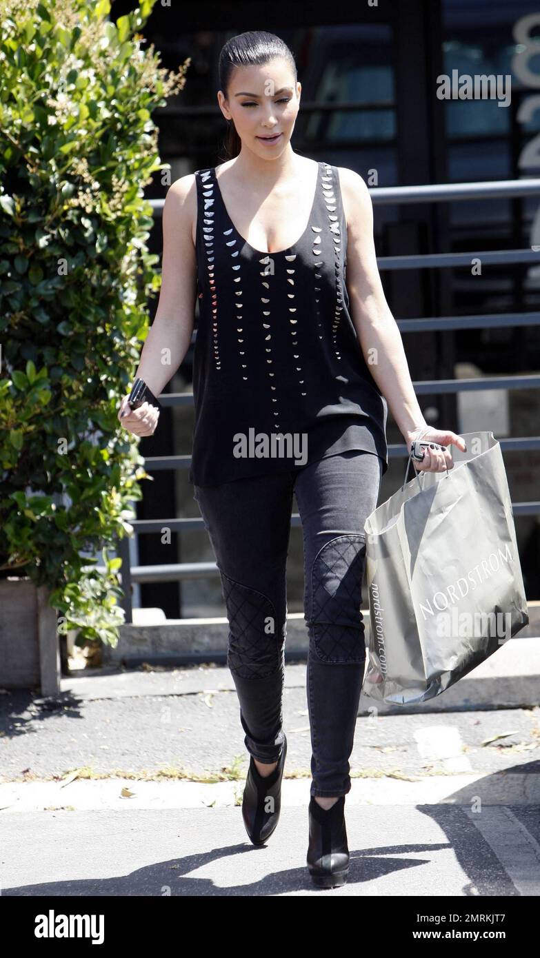 Kim Kardashian muestra un de piel en una camiseta negra estampada con lentejuelas en forma de media luna mientras hace algunas compras en CA. 5/24/10 Fotografía stock - Alamy
