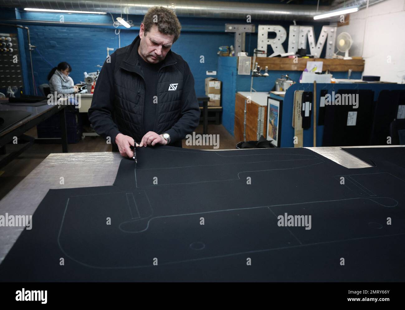 Un trabajador corta un trozo de tela en el departamento de molduras de la fábrica de Aurrigo en Coventry, Gran Bretaña, el 18 de enero de 2023. REUTERS/Phil Noble Foto de stock