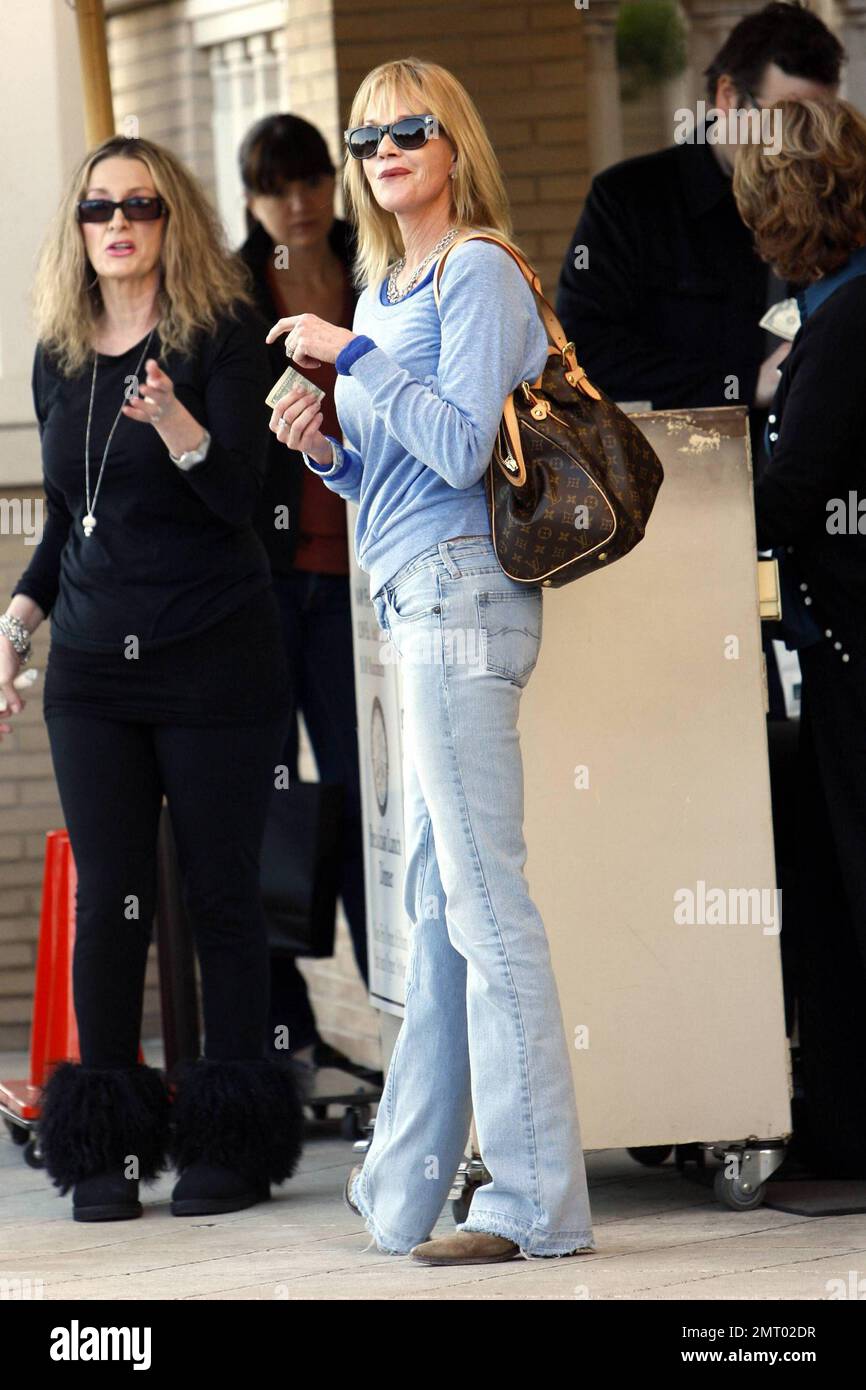 La actriz Melanie Griffith se vuelve casual con una sudadera gris, jeans y botas  marrones mientras compra en Barney's New York. Los Ángeles, CA. 12/8/10  Fotografía de stock - Alamy