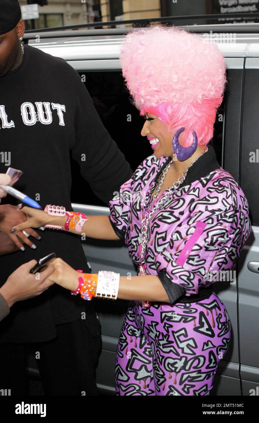 El rapero trinitense-estadounidense y cantante/compositor de R&B Nicki  Minaj sonríe cuando llega a BBC Radio 1. Con una peluca rosa grande, un  traje de salto rosa con un estampado salvaje y un