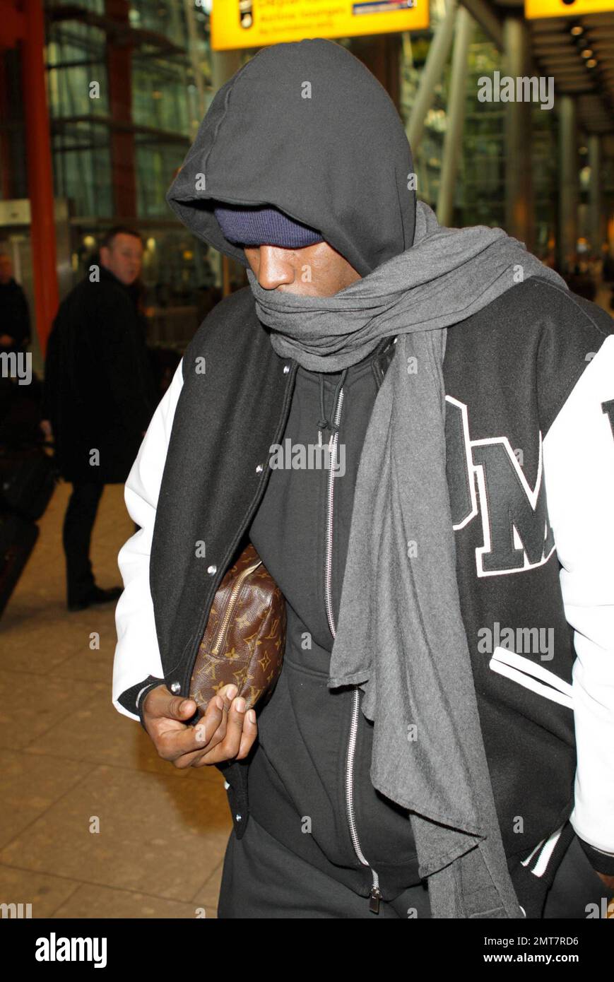 Sean 'P Diddy' Combs se cubre con una sudadera negra con capucha, un  sombrero azul y una bufanda gris cuando llega al aeropuerto de Heathrow de  Londres. El magnate de la música