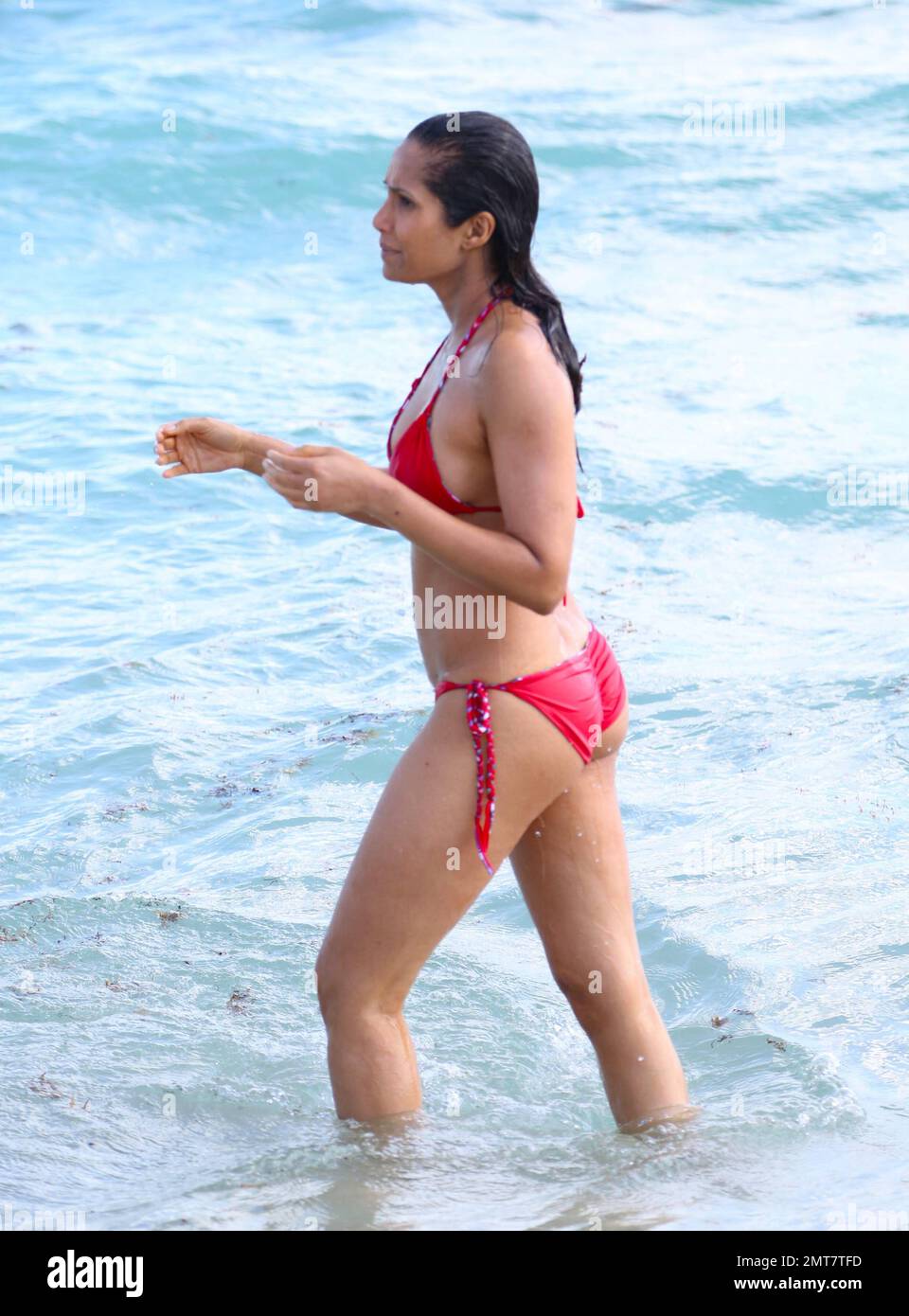 Padma Lakshmi se ve impresionante en un bikini de cadena roja mientras se  da un chapuzón en el océano de Miami. Miami Beach, FL. 8 de febrero de 2015  Fotografía de stock - Alamy