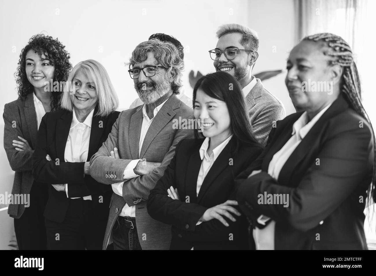 Gente de negocios multirracial que trabaja dentro de la oficina del banco - se centran en la cara del hombre derecho - edición en blanco y negro Foto de stock