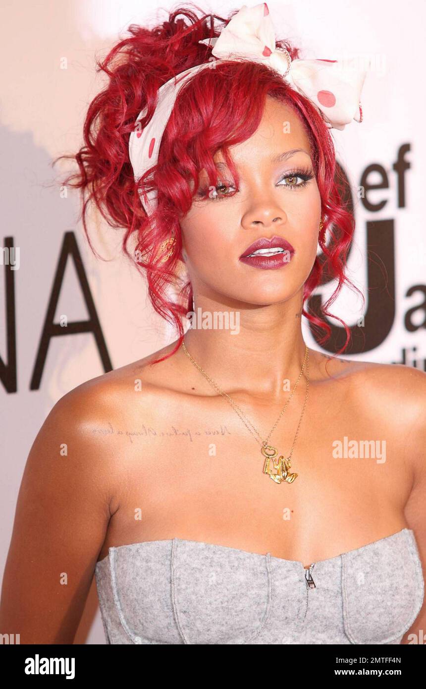 Con el pelo rojo brillante y un traje festivo, la estrella del pop Rihanna  actúa y posa en la alfombra roja durante la ceremonia de iluminación del  árbol de Navidad en el