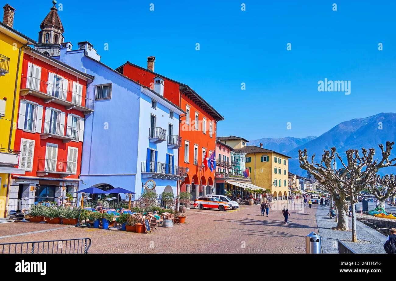Paseo junto al lago de Ascona con una vista de la línea de casas de color, restaurantes y bares al aire libre, Suiza Foto de stock