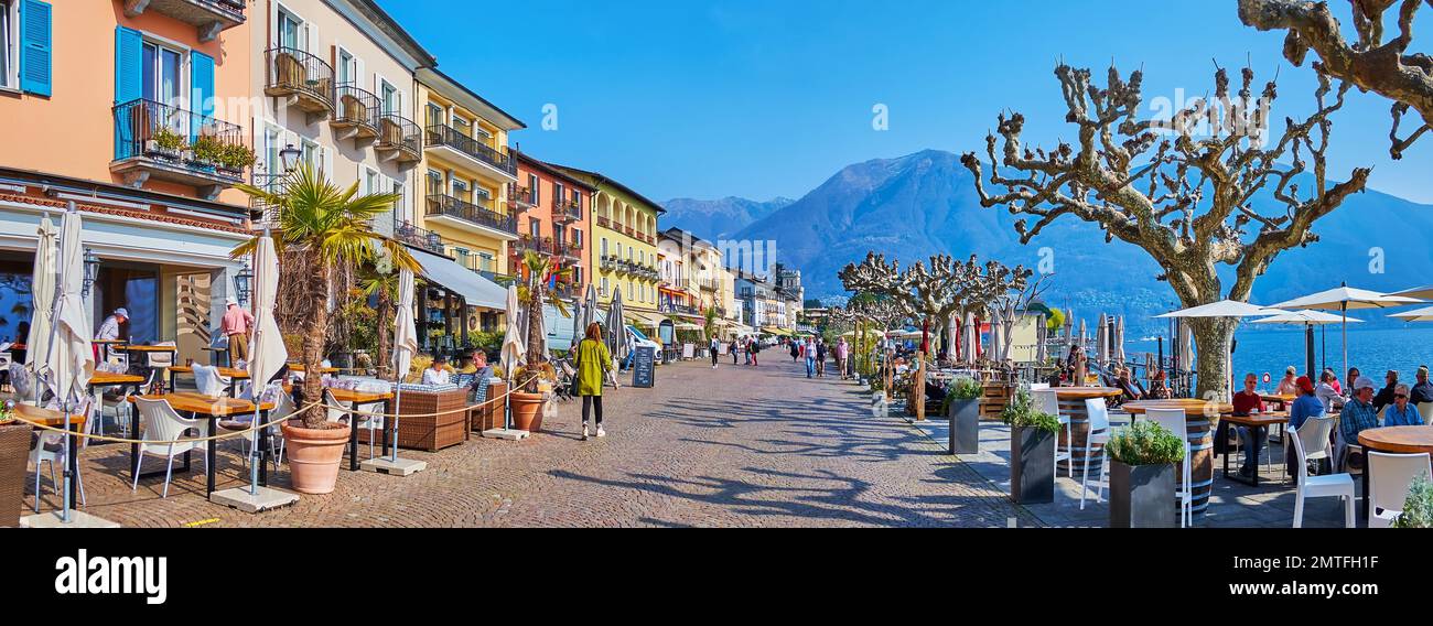 Camine por la Piazza Giuseppe Motta con casas vintage de colores, cafés, bares, tiendas de recuerdos y una vista sobre el lago Maggiore, Ascona, Suiza Foto de stock