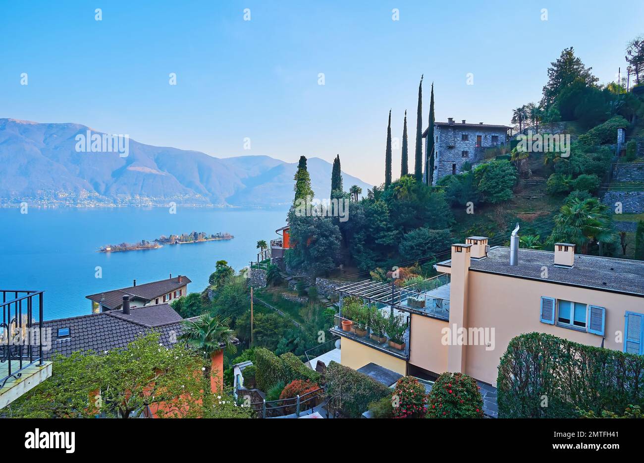 Los jardines de la terraza floreciente en la ladera de la montaña contra las aguas azules del lago Maggiore, las islas Brissago y los Alpes brumosos, Ronco sopra Ascona, Suizla Foto de stock