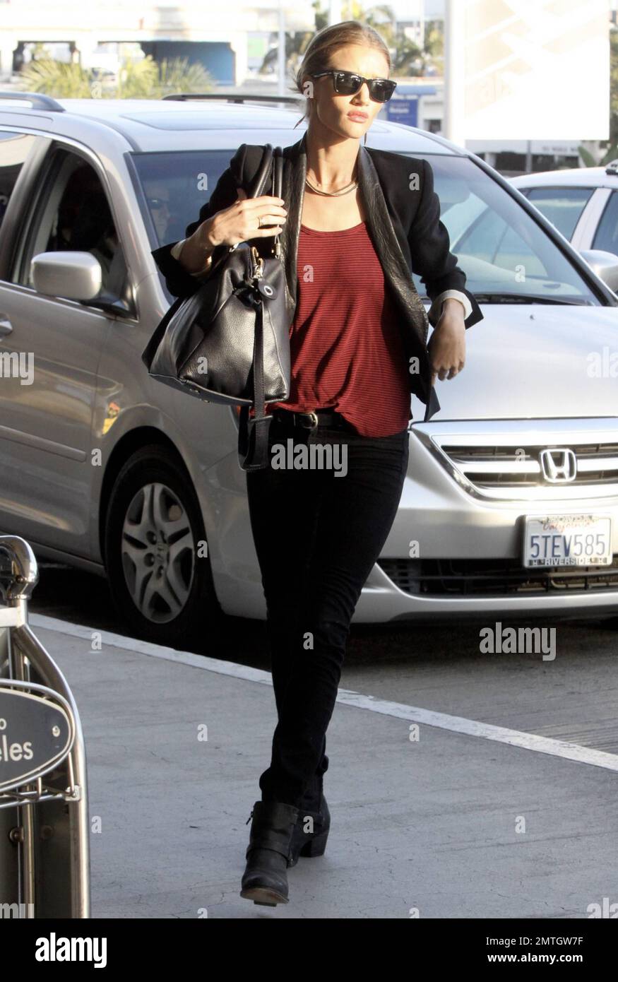 La modelo y actriz británica Rosie Huntington-Whiteley se ve encantadora  con jeans negros, un top rojo y una chaqueta negra cuando llega al  aeropuerto internacional de Los Ángeles. Los Ángeles, CA. 12th