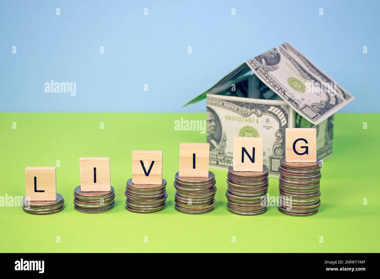 El costo de vida aumenta el concepto con la casa del dinero y cuartos apilados Foto de stock