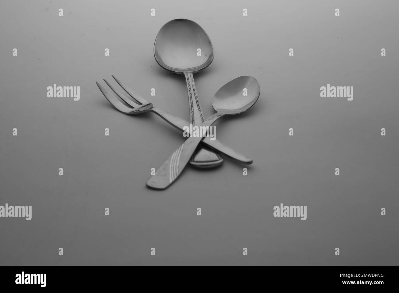 La cuchara de plata, tenedores y cubiertos de cuchillo aislados en el fondo de mesa gris vacío Foto de stock