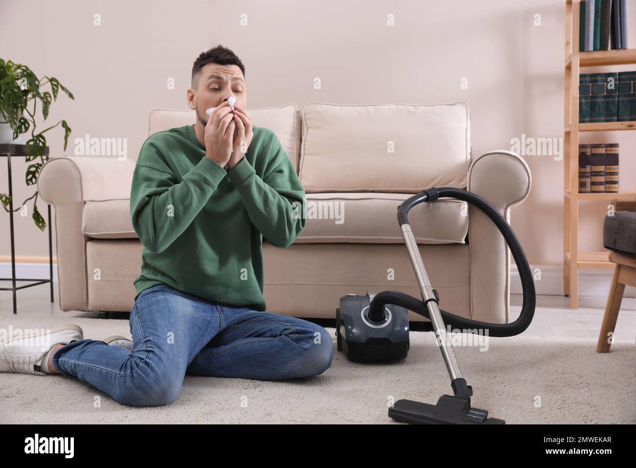 Hombre con aspiradora que sufre de alergia al polvo en Fotografía de stock - Alamy