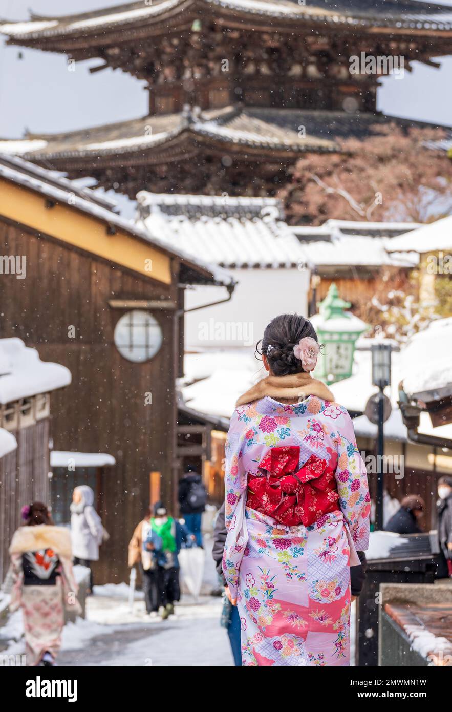 Vista trasera de una joven asiática que llevaba kimono tradicional japonés en la calle Sannen-zaka con nieve en invierno. Kioto, Japón. Yasaka Pagoda Foto de stock