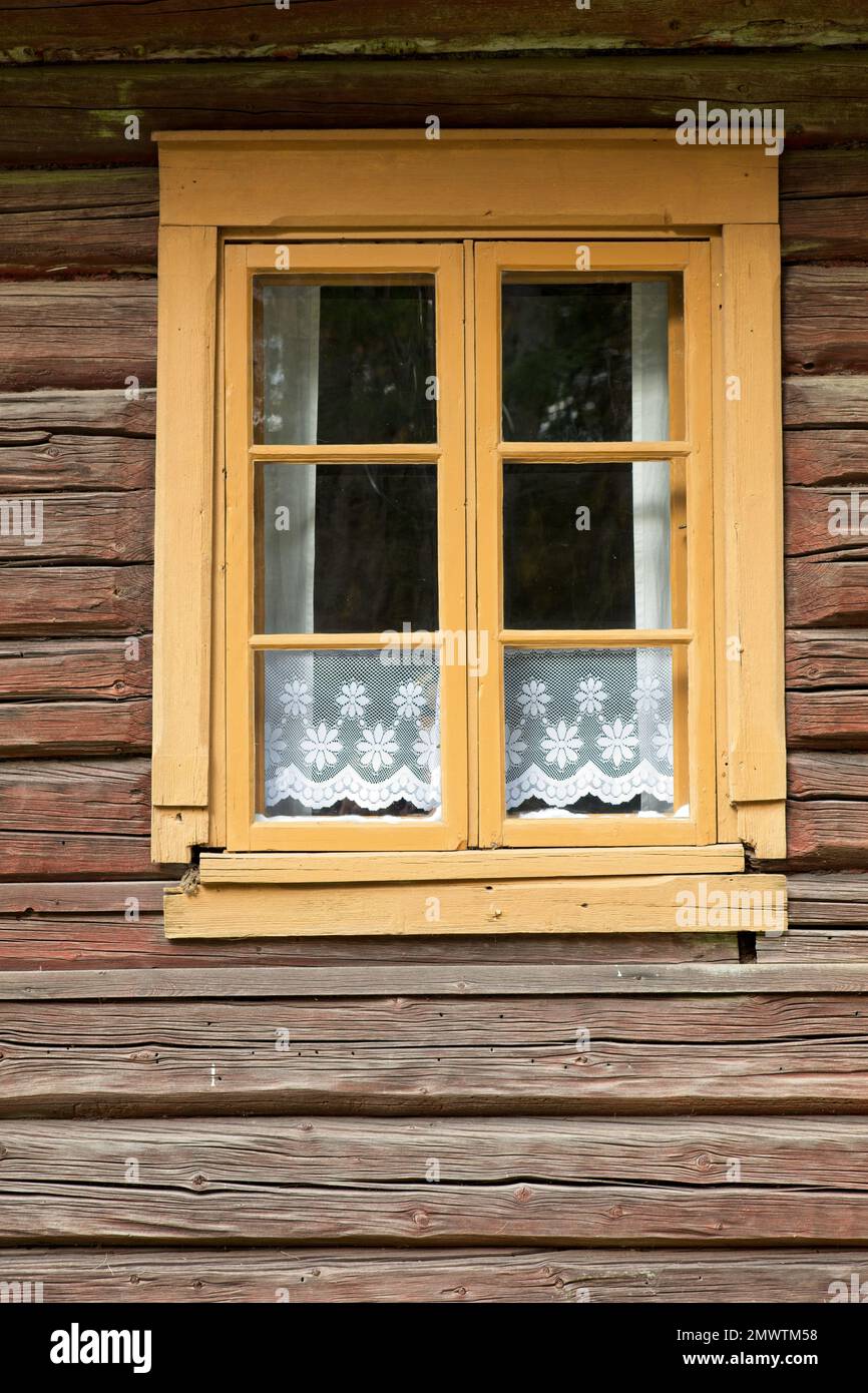 Ventanas enmarcadas en amarillo en un antiguo edificio de madera desgastada  con cortinas de encaje blanco tradicional en la ventana Fotografía de stock  - Alamy