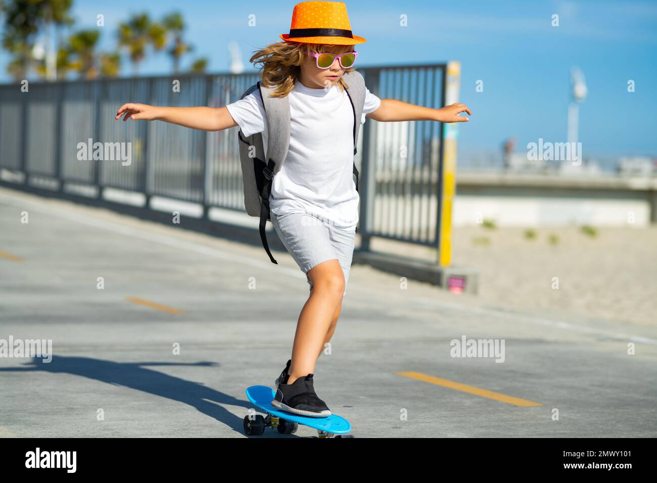 Niños deportivos de verano con skateboard. Niño montando skateboard en la  carretera. Niño practicando skateboard. Los niños aprenden a montar en  patineta en un parque Fotografía de stock - Alamy