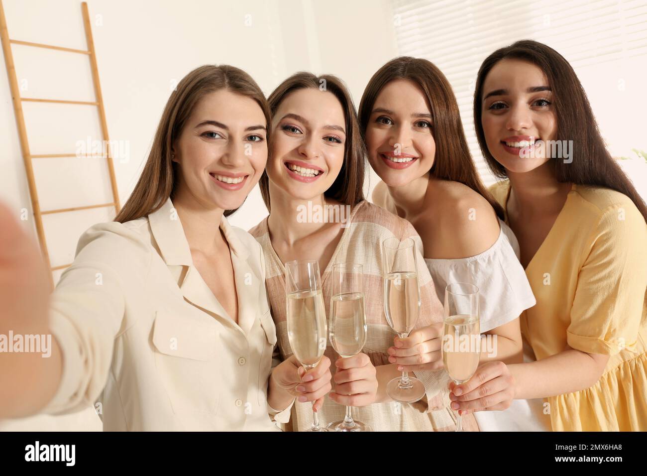 Hermosas señoritas con champán tomando selfie en el interior. Día de la  Mujer Fotografía de stock - Alamy