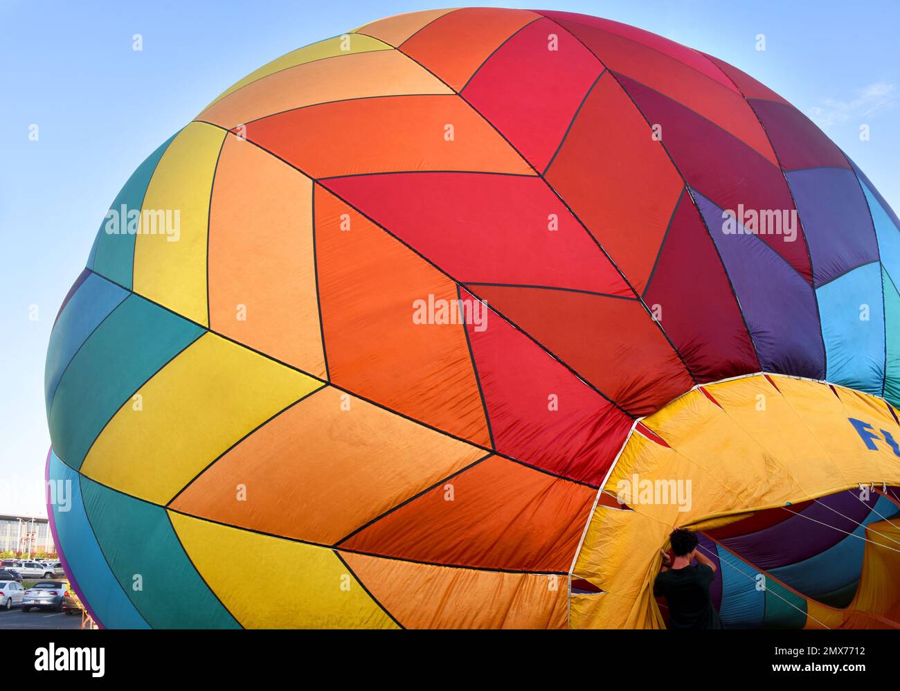 Colores brillantes forman patrones geométricos en este globo de aire caliente. El globo se está inflando. Foto de stock