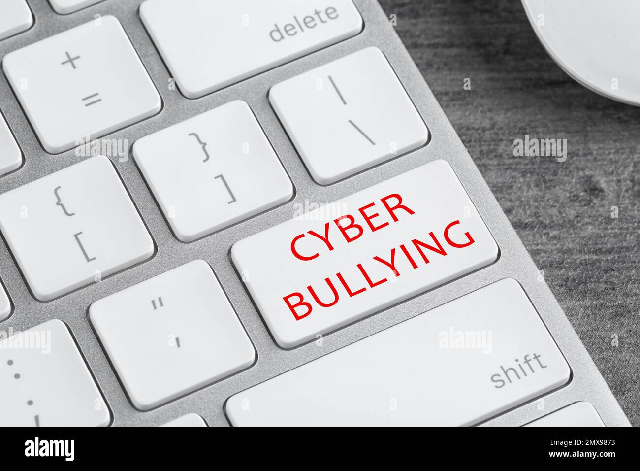 Teclado portátil moderno con frase CYBER BULLYING en el botón blanco