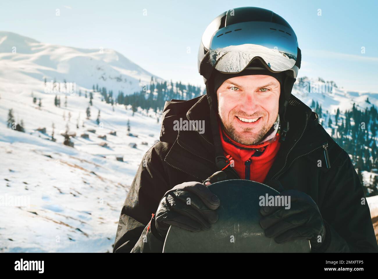 Gafas de esquí de un hombre con el reflejo de las montañas fondo