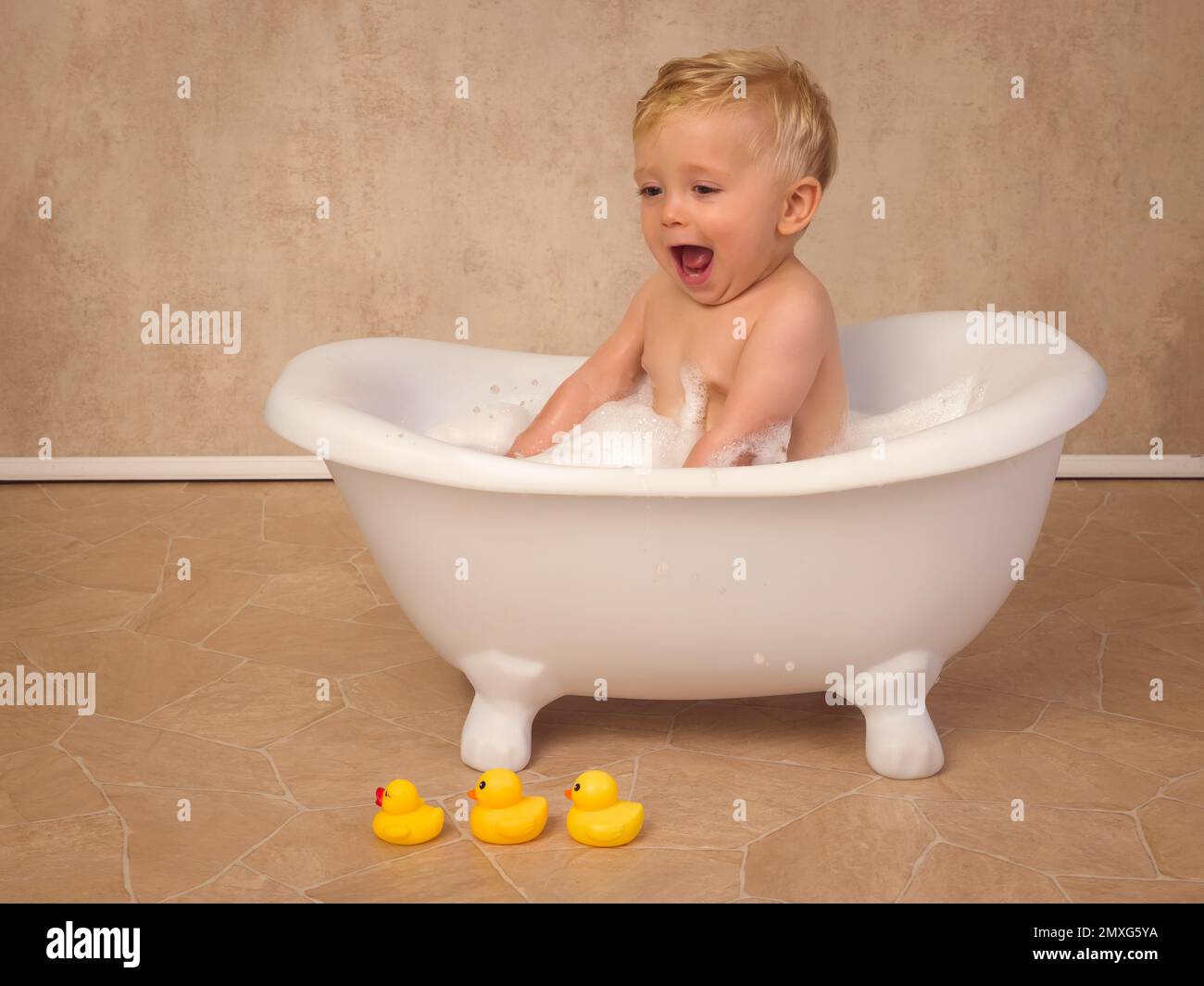 Escenas felices de un pequeño bebé lindo de 12 meses de edad sentado en una  bañera blanca vintage salpicando con agua y jabón Fotografía de stock -  Alamy