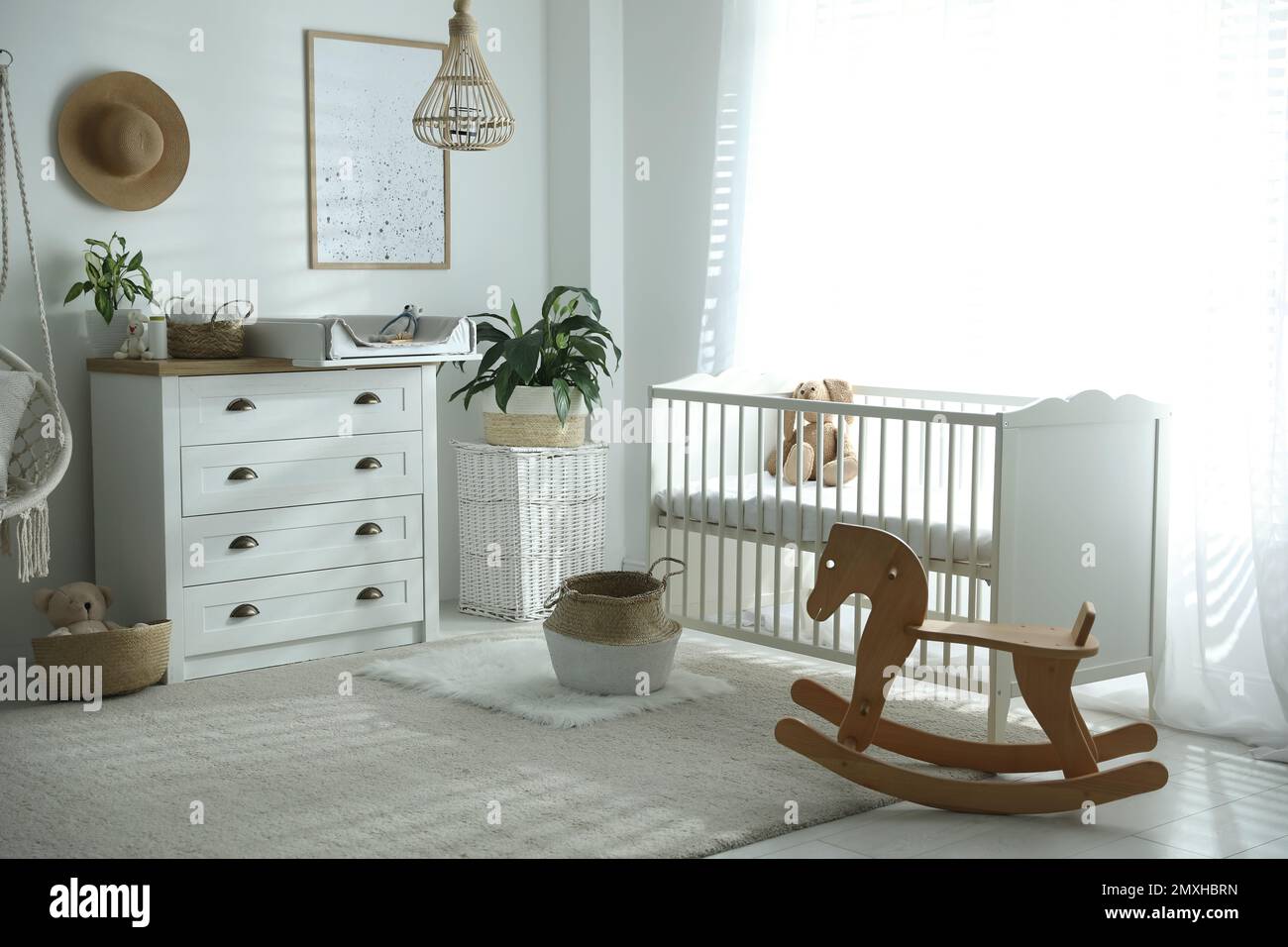 Cajonera con cambiador y almohadilla cerca de una cómoda cuna en la  habitación del bebé. Diseño de interiores Fotografía de stock - Alamy