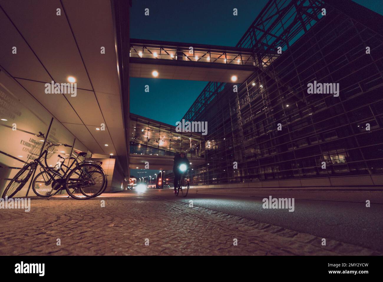 bicicletas en la calle de la ciudad de noche con arquitectura moderna Foto de stock