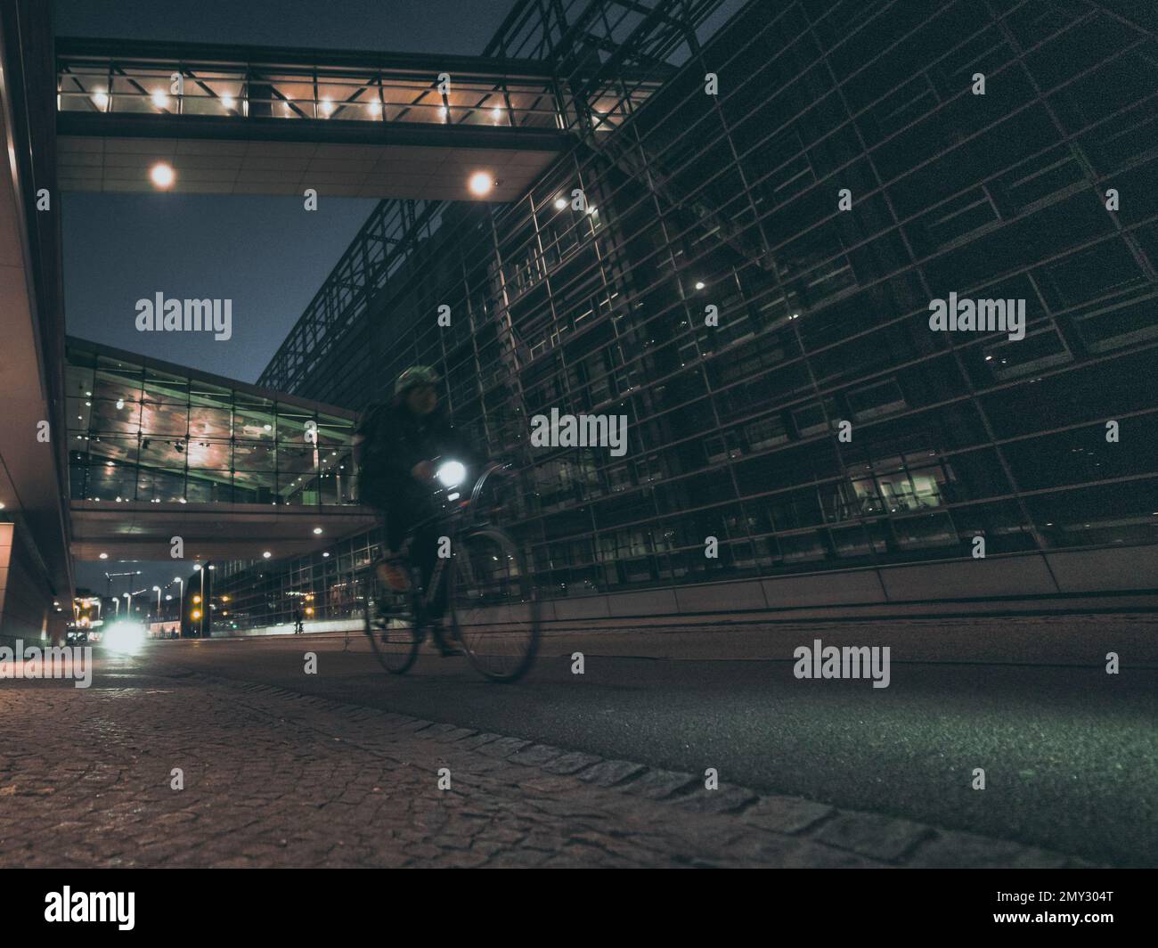 ciclista en la calle de la ciudad de la noche con la arquitectura moderna Foto de stock