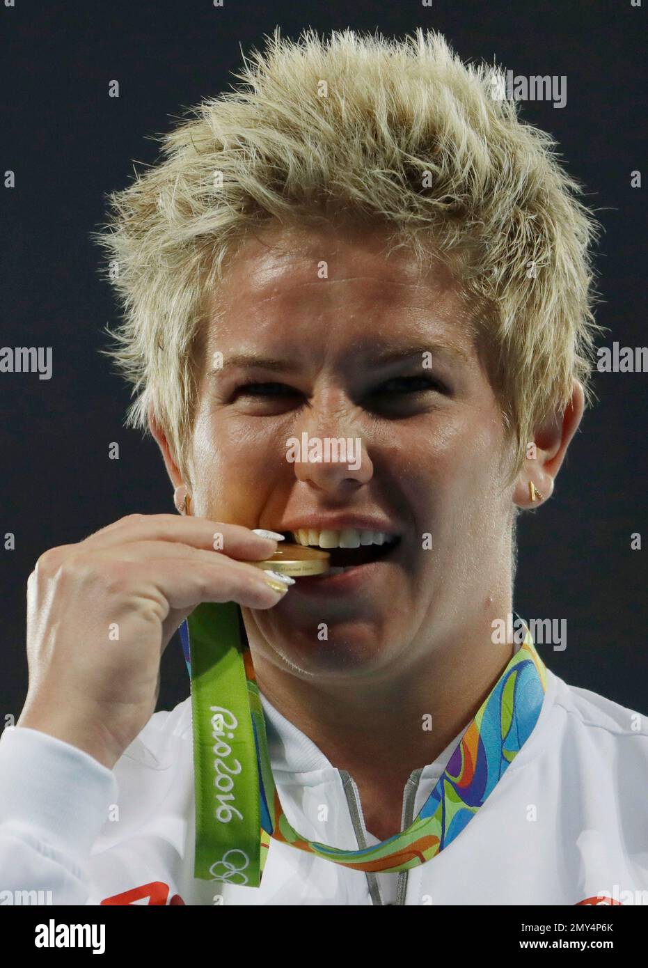 Poland's gold medal winner Anita Wlodarczyk bites her gold medal after winning the women's