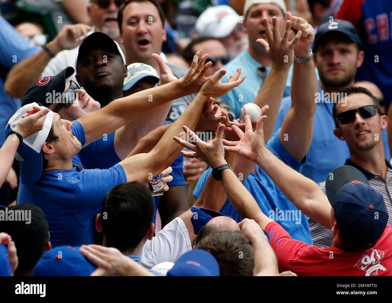Baseball fans battle for the foul ball hit by Chicago Cubs' Kyle