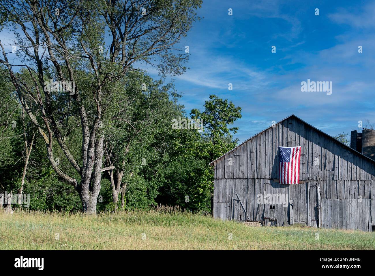Bandera americana en el viejo granero de la granja desgastada Foto de stock