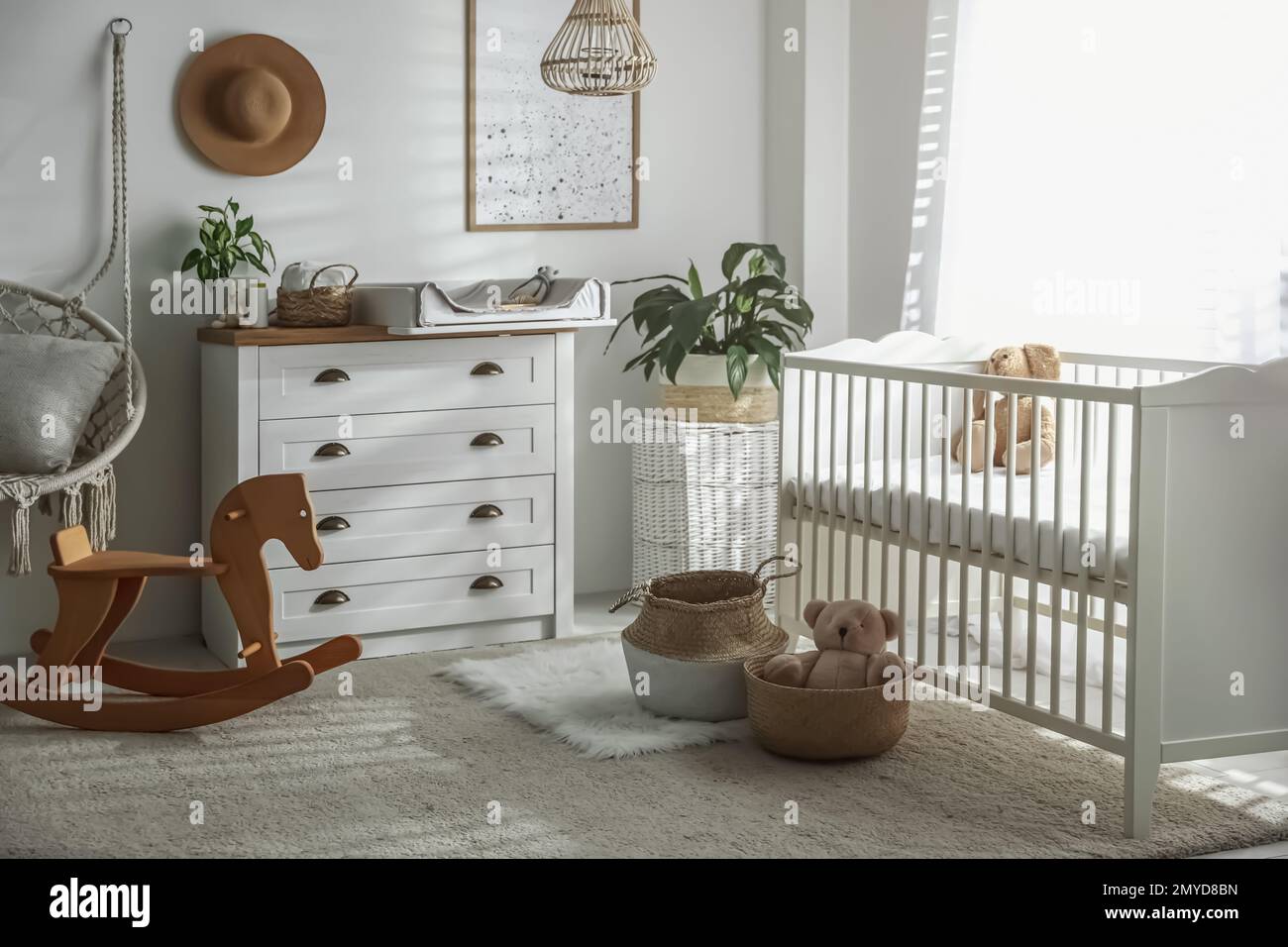 Cajonera con cambiador y almohadilla cerca de una cómoda cuna en la  habitación del bebé. Diseño de interiores Fotografía de stock - Alamy