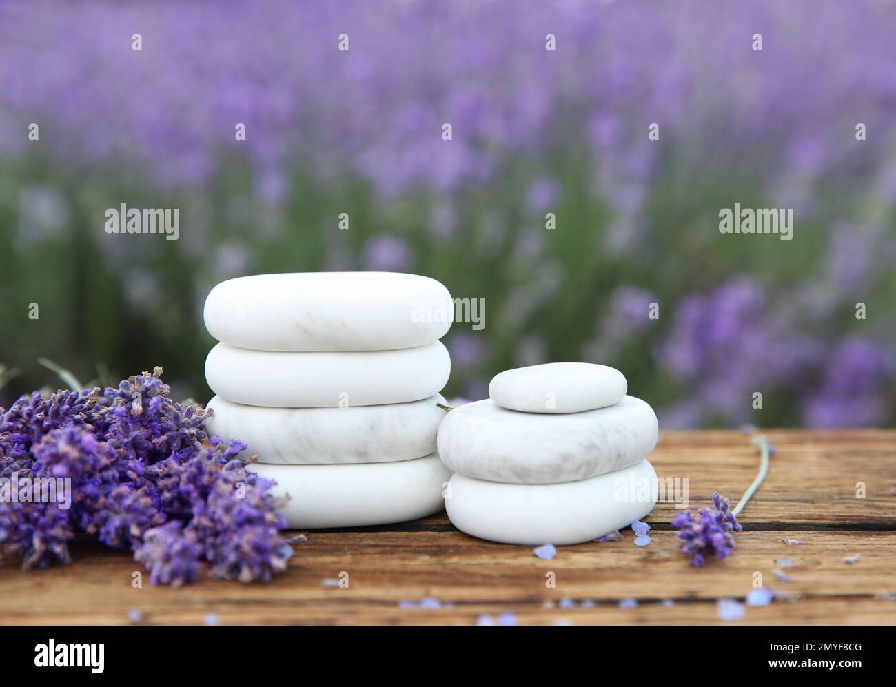 Piedras de spa, flores de lavanda fresca y sal de baño en la mesa de madera  al aire libre, primer plano Fotografía de stock - Alamy