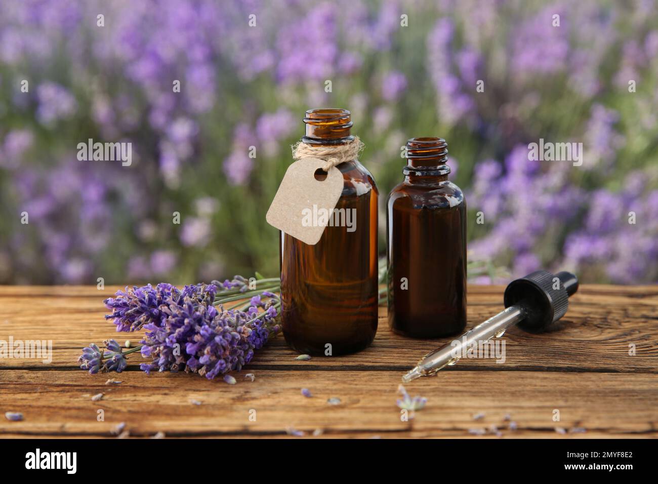 Botellas de aceite esencial natural, pipeta y flores de lavanda en la mesa  de madera Fotografía de stock - Alamy