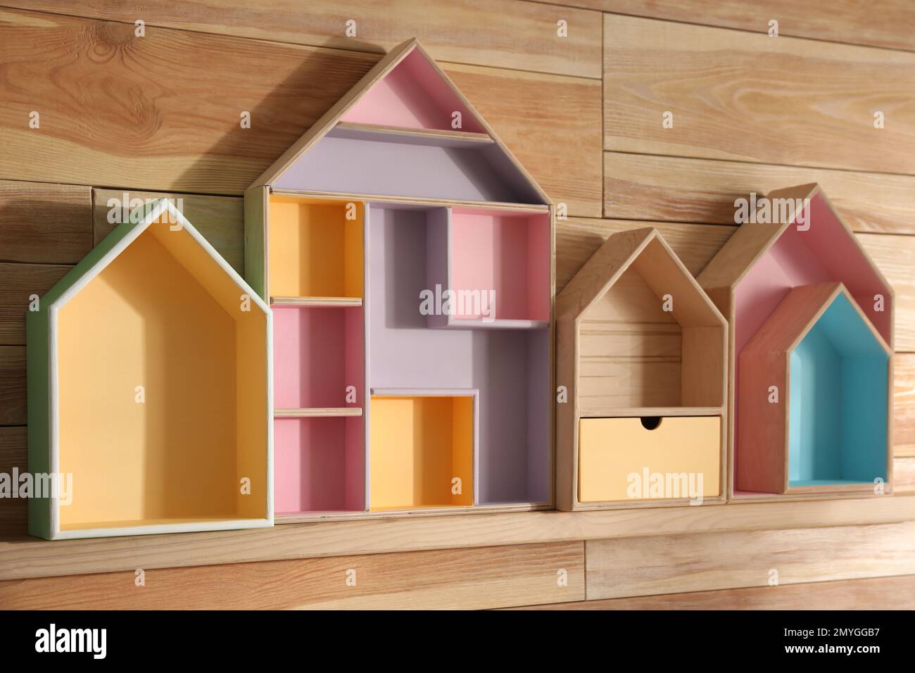 Estantes pintados en forma de casa en la pared de madera. Elementos  interiores Fotografía de stock - Alamy