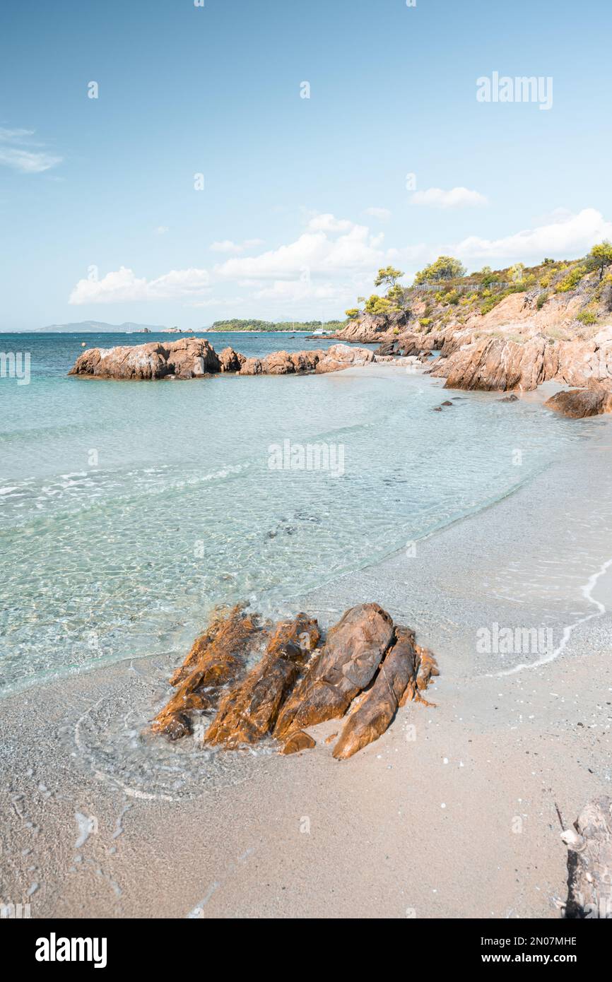Una playa rocosa con agua perfectamente azul y un hermoso paisaje en un día  de verano en Bormes-Les-Mimosas, Francia Fotografía de stock - Alamy