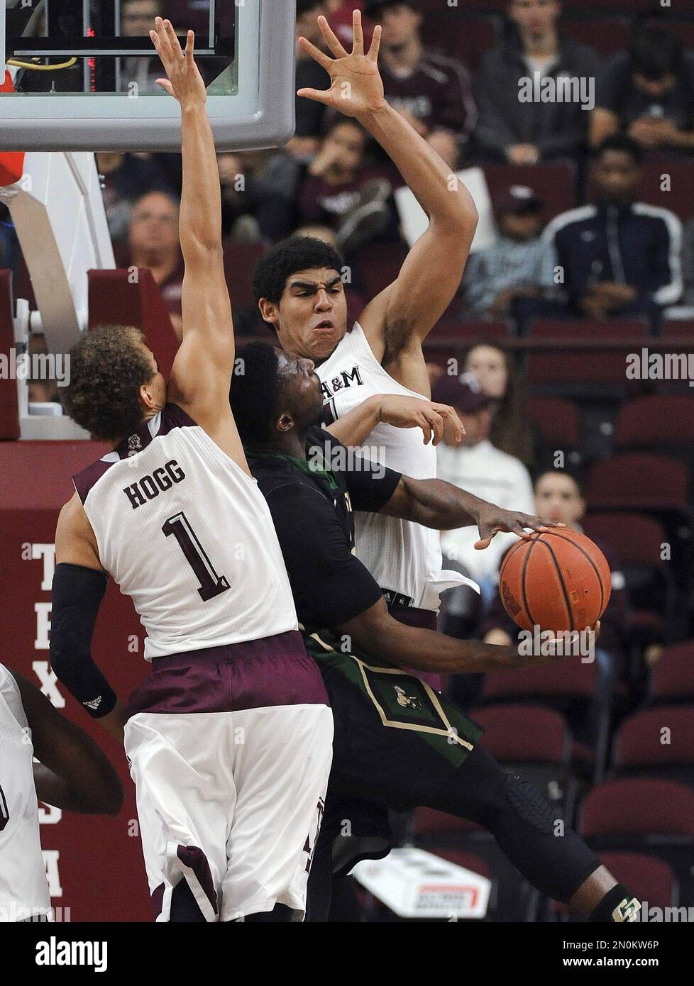 Cal Poly guard David Nwaba, center, tries to shoot as Texas A&M forward