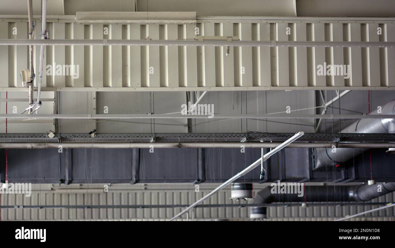 Luces y sistema de ventilación en el techo de la sala del supermercado. Construcción en el techo. Foto de stock