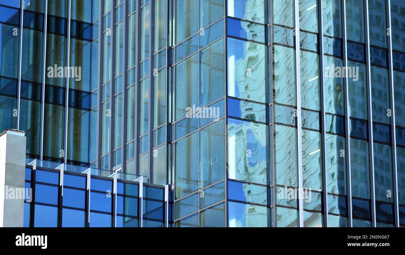 Textura de fachada de un edificio de oficinas con espejo de vidrio. Fragmento de la fachada. Vista inferior de los modernos rascacielos en el distrito de negocios Foto de stock