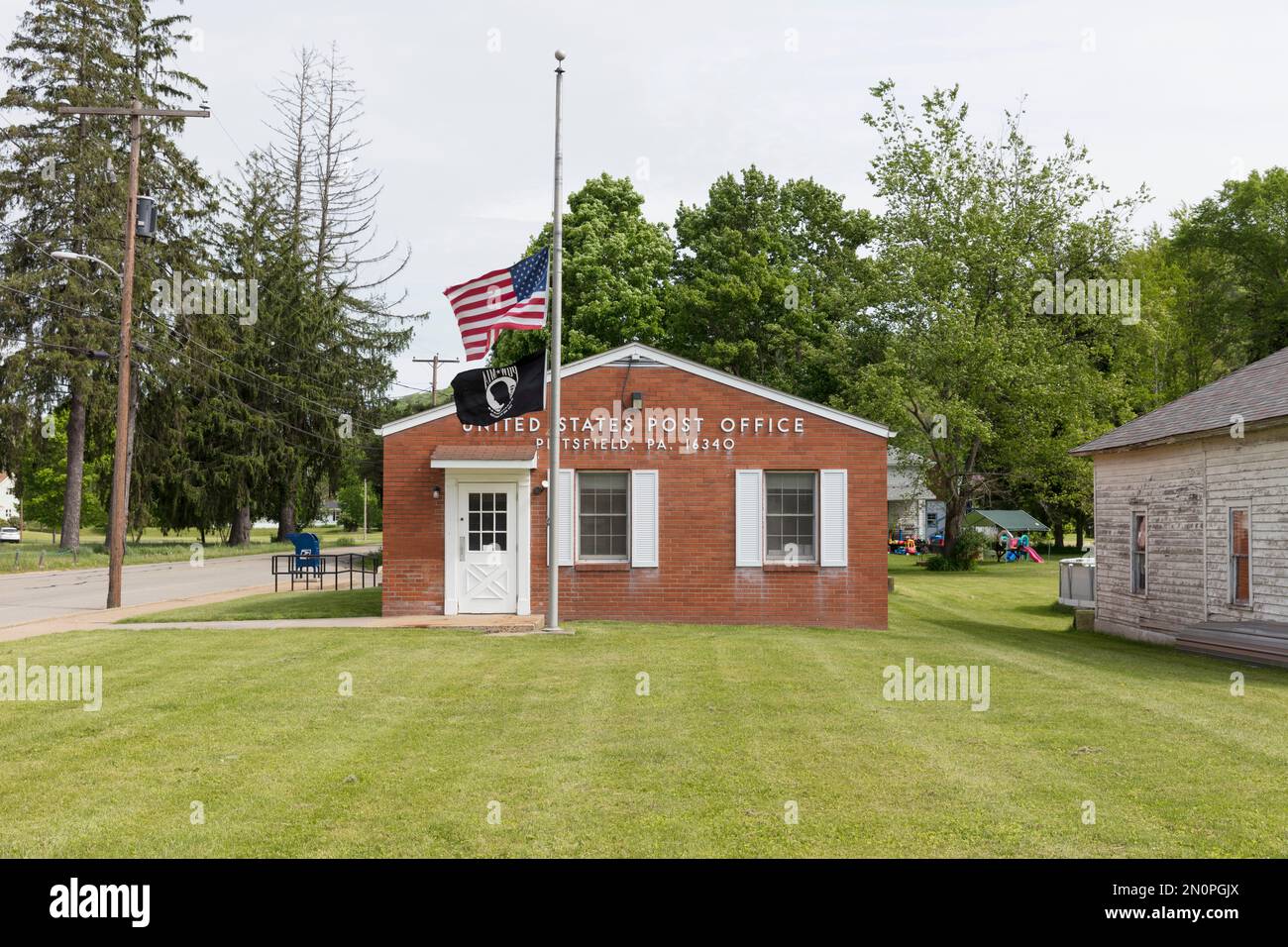Edificio rural de oficinas de correos de Estados Unidos, con una bandera americana volando. Foto de stock