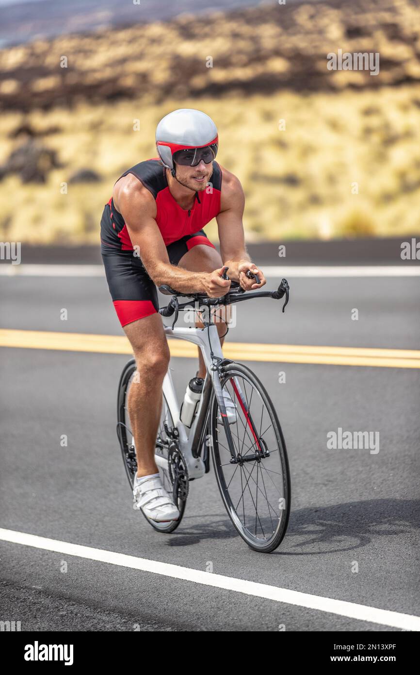 Triatlón de prueba de tiempo de ciclismo hombre triatleta que lleva casco  de bicicleta aerodinámica con visera de ciclismo en el día de la carrera de  competición montando bicicleta de carretera tiro