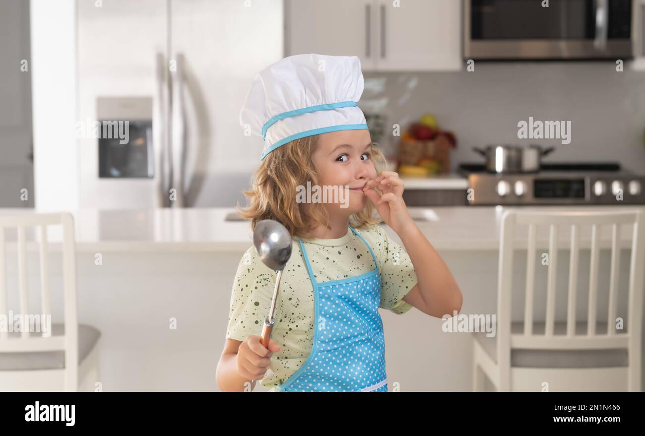 Niño cocinero con de cocina y sombrero de chef preparando la comida en la Concepto de cocina, y comida para niños Fotografía de stock -