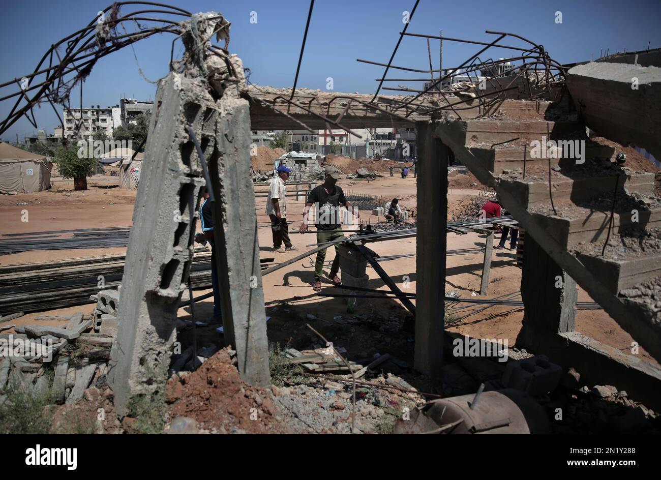 A Palestinian worker prepares rebar to rebuild a house which was destroyed during the last