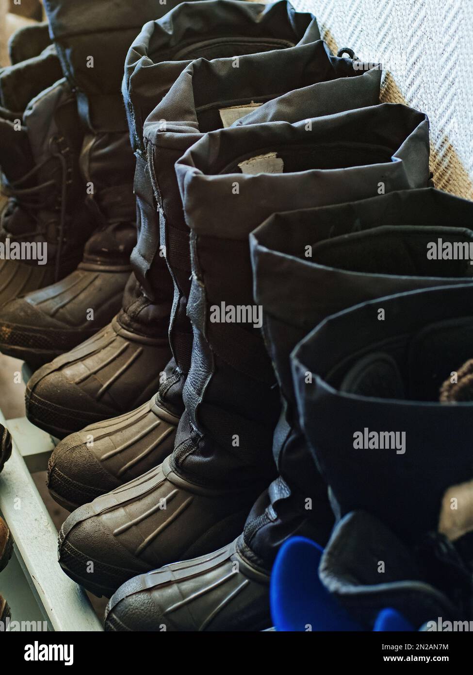 Calzado de trabajo cálido. Las botas industriales invierno de los trabajadores están en fila en la sala de secado. Fondo Fotografía de stock - Alamy
