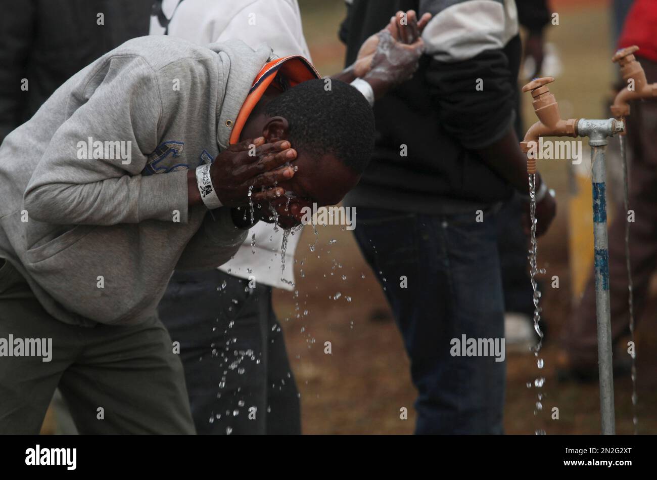 A Man Washes Himself At A Tap At A Temporary Shelter Set Up For Foreign Nationals Fleeing 