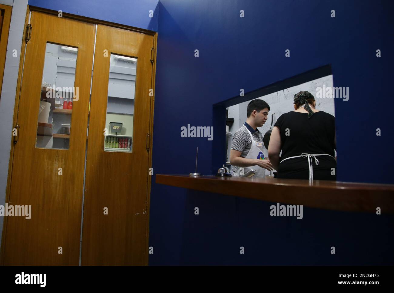 In this April 7, 2015, photo, a trainee with autism, left, makes a