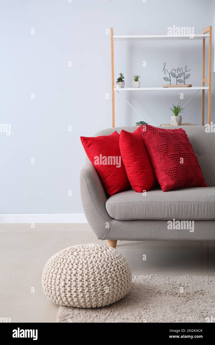 Interior de sala de estar moderna con almohadas rojas en sof gris