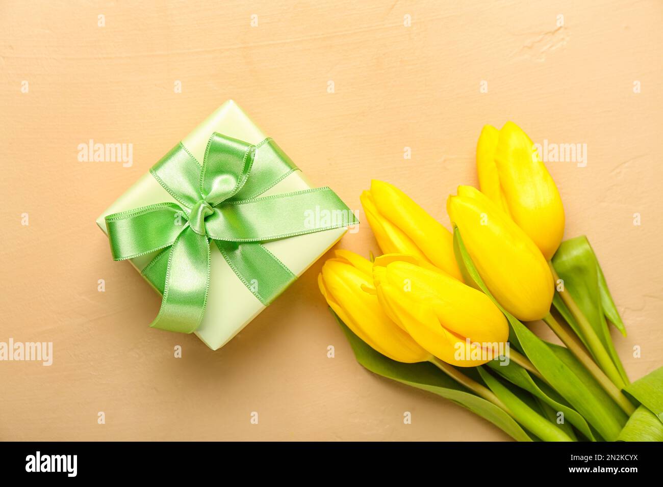 Caja de regalo y hermosas flores de tulipán sobre fondo beige. Hola  primavera Fotografía de stock - Alamy